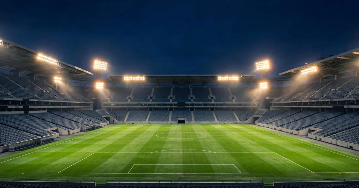 Empty football stadium glowing under floodlights at night